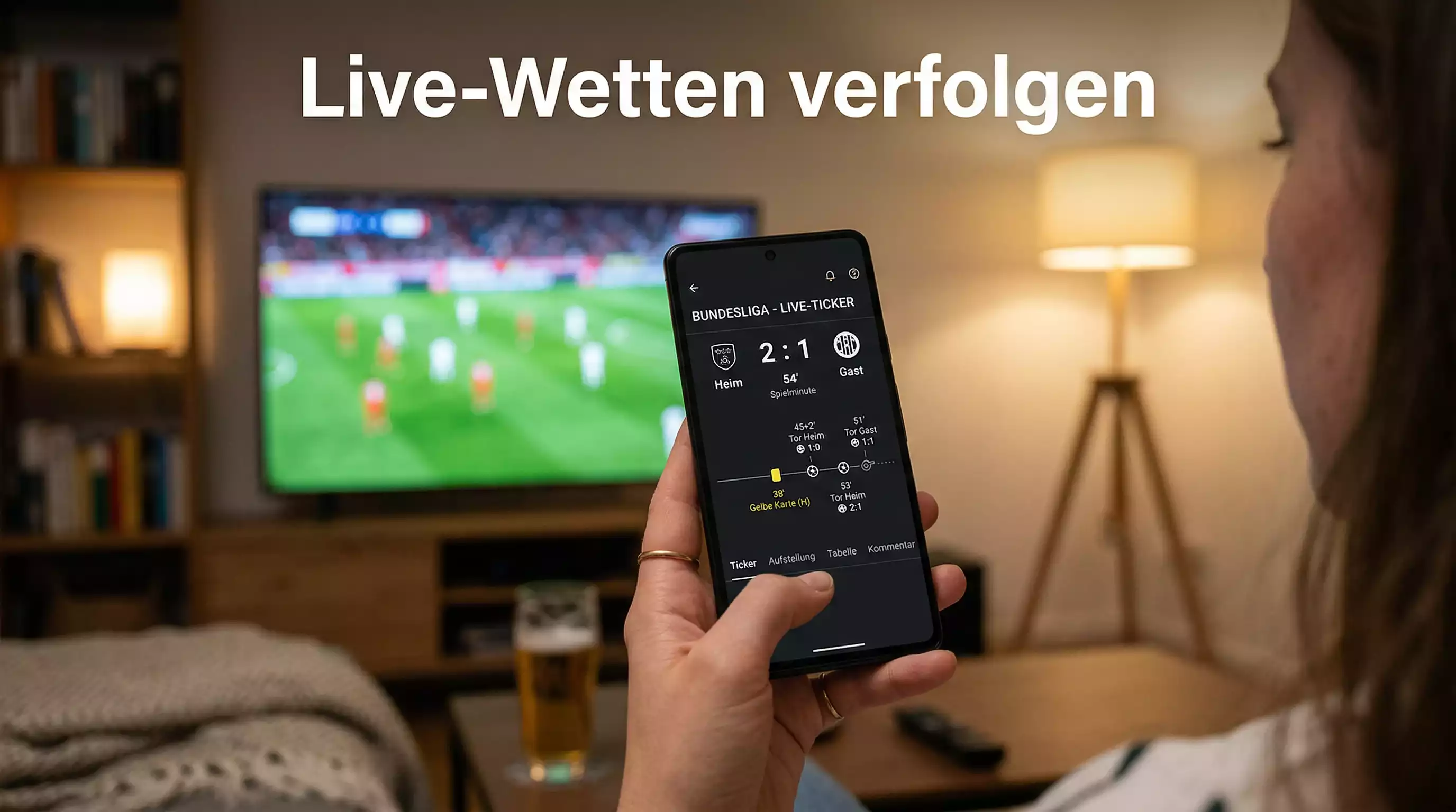 Smartphone zeigt Live-Spielstand während eines Fussballspiels im Hintergrund